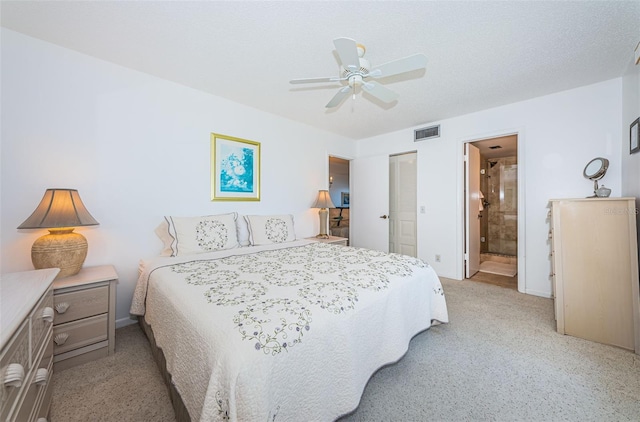 bedroom featuring a closet, visible vents, a ceiling fan, a textured ceiling, and ensuite bath