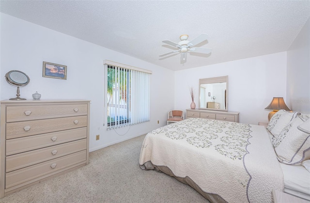 bedroom featuring carpet floors, a textured ceiling, and a ceiling fan