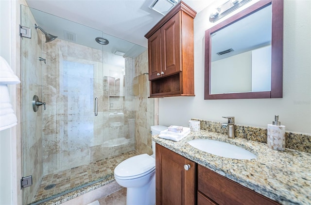 bathroom with a shower with door, vanity, and toilet