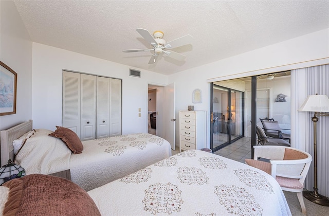 bedroom featuring ceiling fan, access to outside, a textured ceiling, and a closet