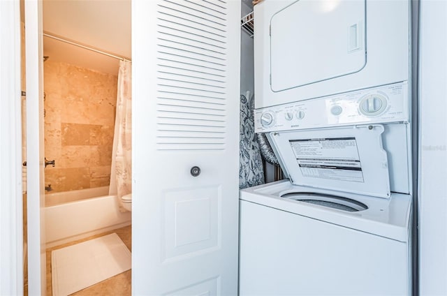 clothes washing area with stacked washer / dryer, laundry area, and tile patterned floors