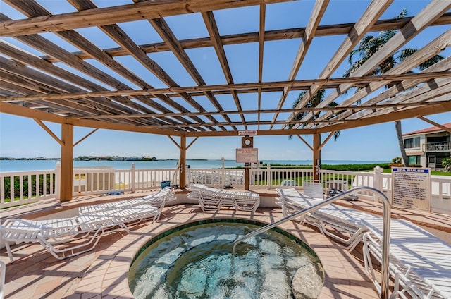 view of patio / terrace featuring a community hot tub and a water view