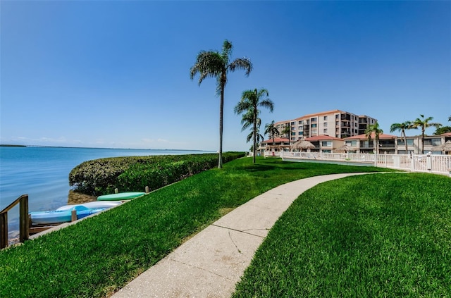 view of home's community featuring a water view and a lawn