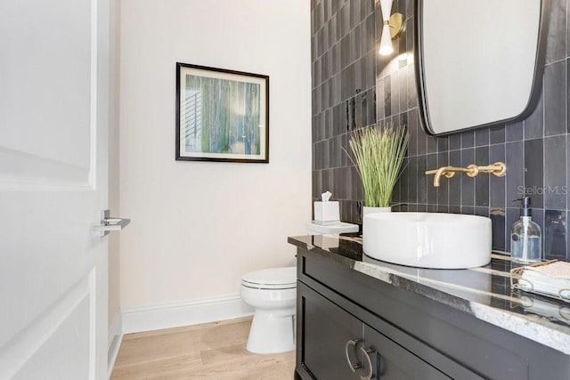 bathroom featuring tile walls, tasteful backsplash, vanity, wood-type flooring, and toilet