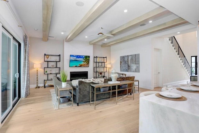 living room with beamed ceiling, ceiling fan, and light hardwood / wood-style floors