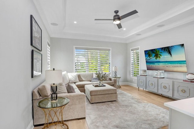 living room with ceiling fan, a raised ceiling, and light hardwood / wood-style flooring