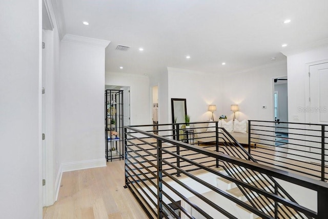 hallway with crown molding and light hardwood / wood-style floors