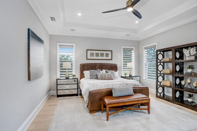 bedroom with a raised ceiling, ornamental molding, ceiling fan, and light hardwood / wood-style flooring