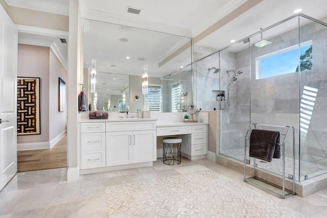 bathroom with vanity, ornamental molding, a wealth of natural light, and a shower with shower door