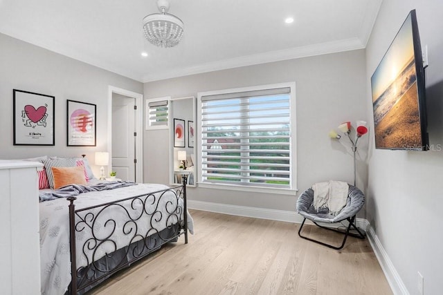 bedroom featuring multiple windows, ornamental molding, and light hardwood / wood-style flooring