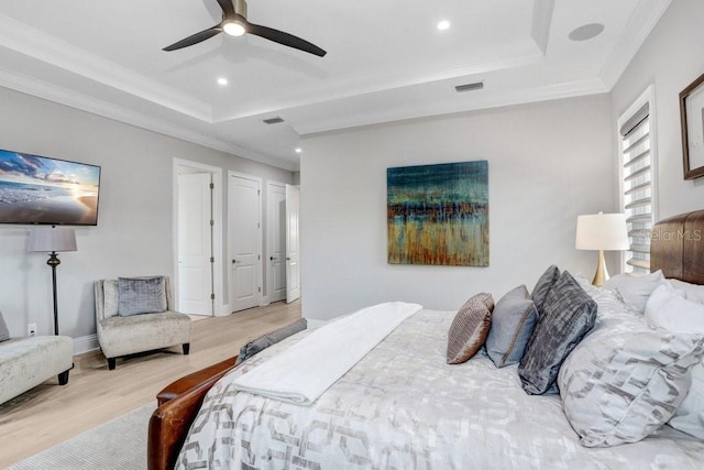 bedroom featuring crown molding, ceiling fan, a raised ceiling, and light hardwood / wood-style flooring