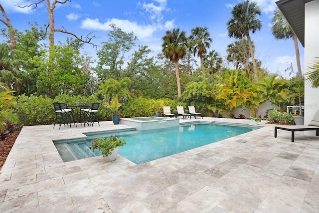 view of swimming pool featuring a patio area and an in ground hot tub