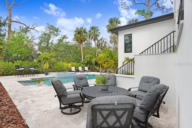 view of patio / terrace with a pool with hot tub