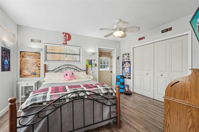 bedroom with dark wood-type flooring, ceiling fan, and a closet