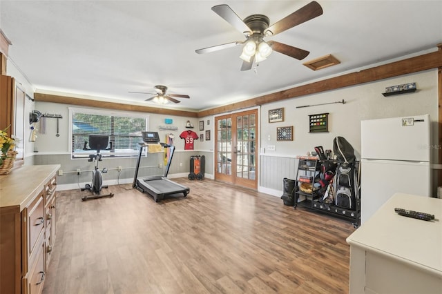 workout area featuring french doors and light wood-type flooring