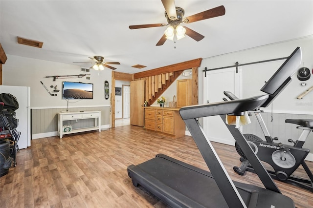 workout room featuring light hardwood / wood-style floors and ceiling fan