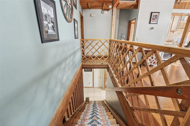 stairway featuring beamed ceiling and tile patterned floors