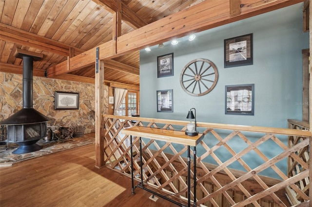 bar with wood ceiling, beamed ceiling, wood-type flooring, and a wood stove