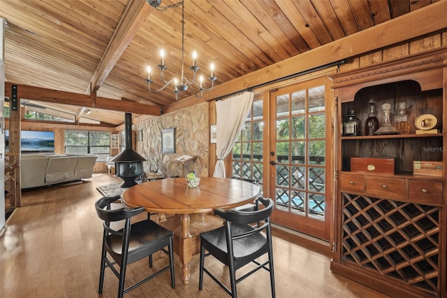 dining space with a wood stove, vaulted ceiling with beams, light hardwood / wood-style floors, wood ceiling, and french doors