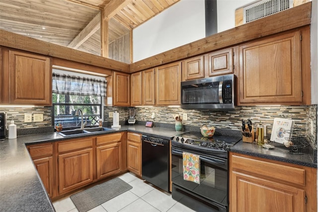 kitchen featuring tasteful backsplash, sink, light tile patterned floors, and black appliances