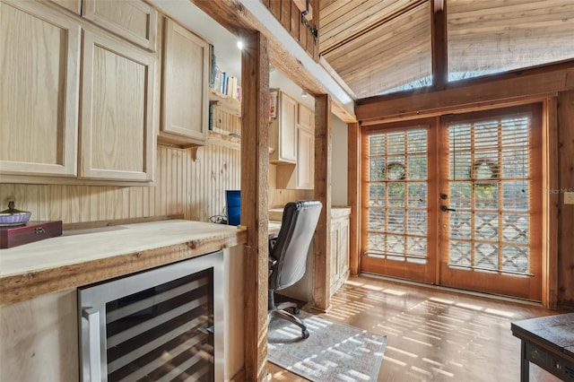 unfurnished office featuring wine cooler, built in desk, vaulted ceiling, and french doors