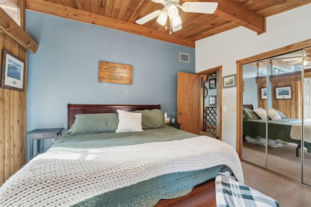 carpeted bedroom with wood ceiling, ceiling fan, a closet, and beamed ceiling