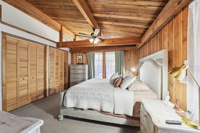 bedroom featuring wooden walls, carpet floors, vaulted ceiling with beams, wood ceiling, and multiple closets