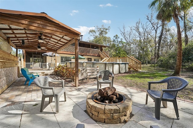 view of patio with ceiling fan and an outdoor fire pit