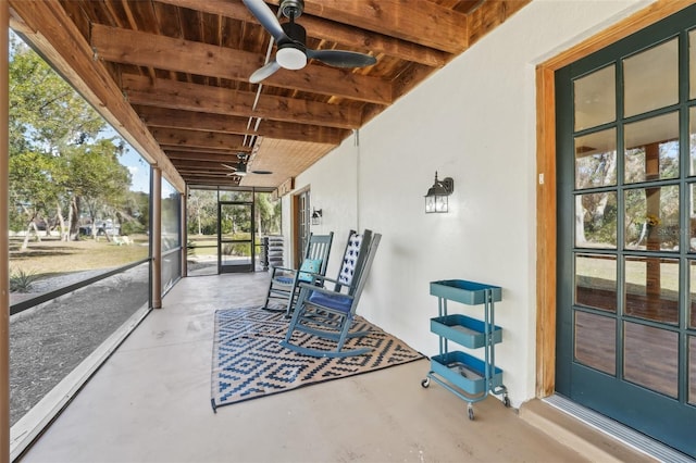 unfurnished sunroom featuring ceiling fan