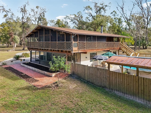 back of house with a sunroom and a yard