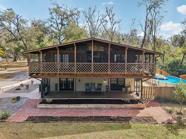 back of property featuring a sunroom and a patio area