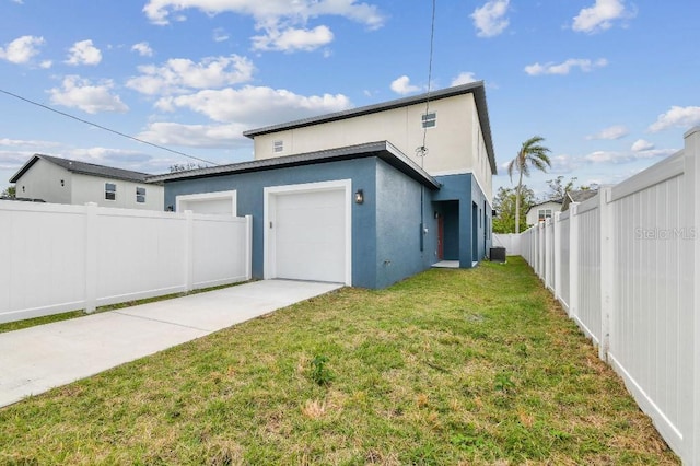 rear view of property with a garage and a lawn