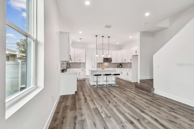 kitchen featuring white cabinetry, plenty of natural light, a center island, and hanging light fixtures