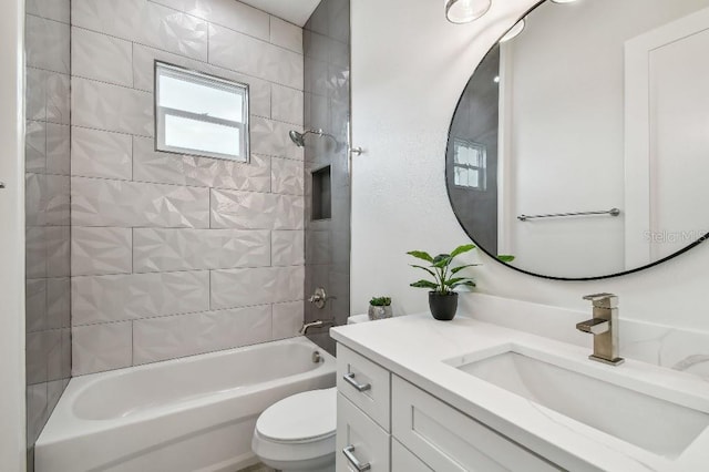 full bathroom featuring tiled shower / bath, vanity, and toilet