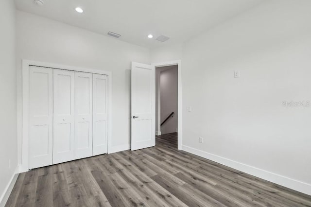 unfurnished bedroom featuring wood-type flooring and a closet