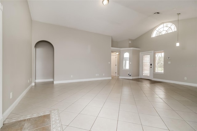 entrance foyer with light tile patterned floors, a wealth of natural light, and high vaulted ceiling