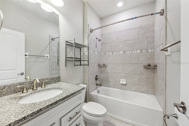 full bathroom featuring tiled shower / bath, vanity, and toilet