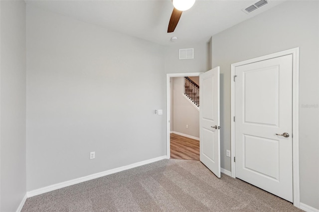 unfurnished bedroom with light colored carpet and ceiling fan