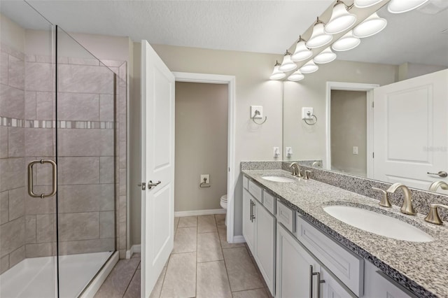 bathroom with vanity, an enclosed shower, toilet, tile patterned floors, and a textured ceiling