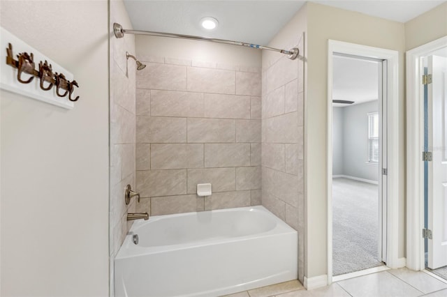 bathroom featuring tiled shower / bath combo and tile patterned flooring