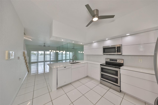 kitchen featuring kitchen peninsula, sink, white cabinetry, light tile patterned floors, and stainless steel appliances