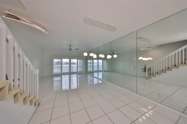 unfurnished room with track lighting, ceiling fan, and light tile patterned floors