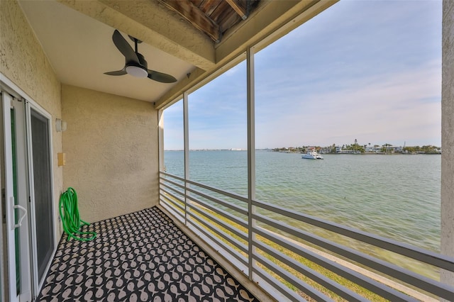 balcony with a water view and ceiling fan