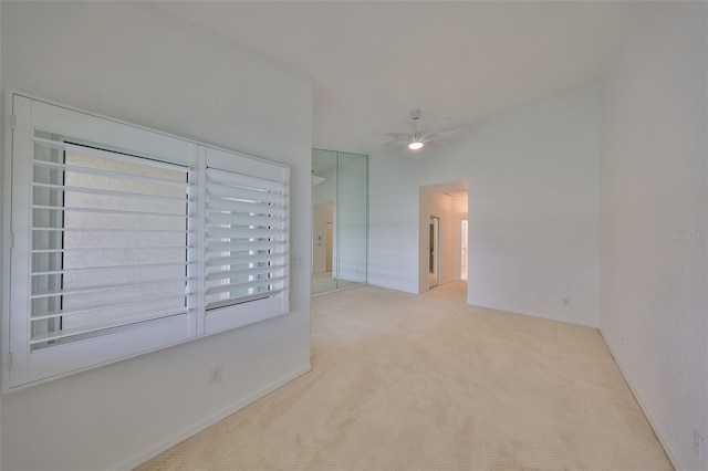 carpeted spare room featuring ceiling fan