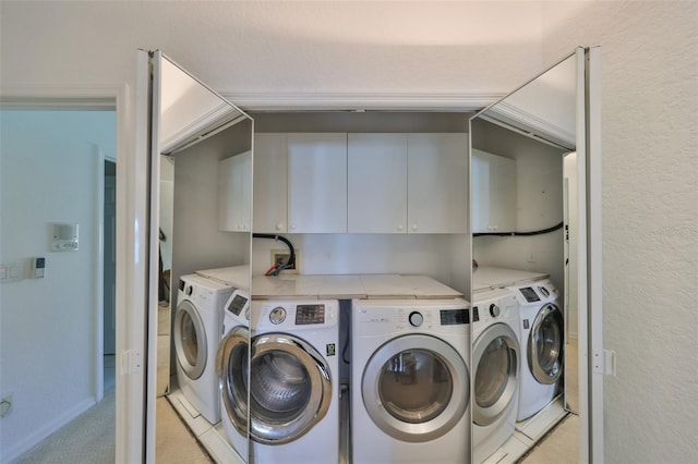 laundry room featuring cabinets, light colored carpet, and washer and clothes dryer