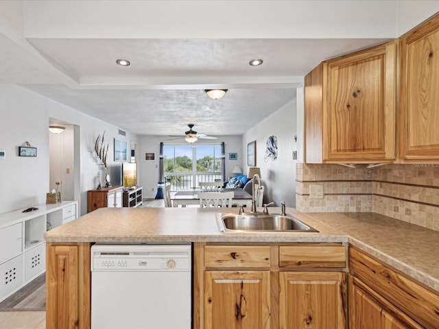 kitchen with sink, white dishwasher, kitchen peninsula, ceiling fan, and decorative backsplash