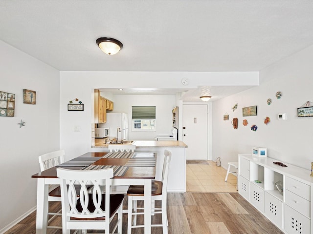 dining area featuring sink and light hardwood / wood-style floors