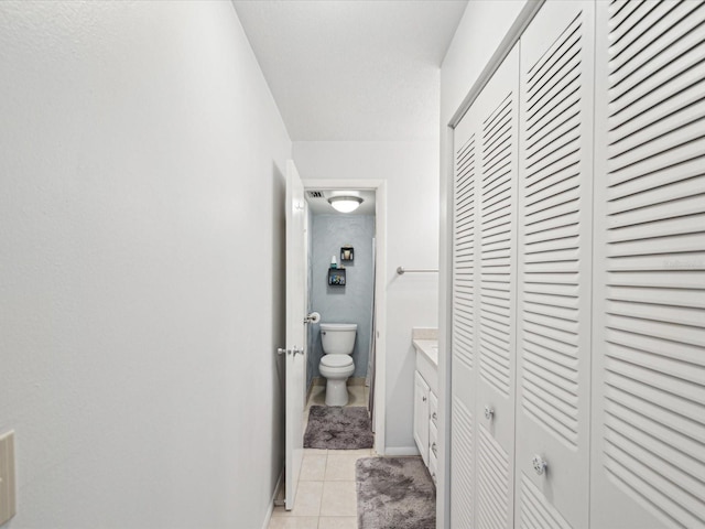 bathroom featuring vanity, tile patterned floors, and toilet