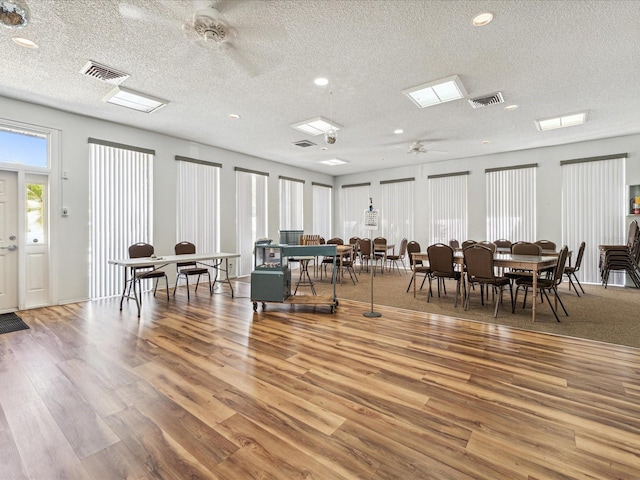 dining space featuring ceiling fan, a textured ceiling, and light hardwood / wood-style floors