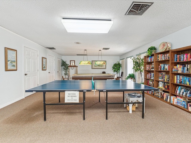 recreation room with carpet and a textured ceiling